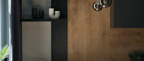 Una cocina moderna con encimera de madera, estantes negros y luces colgantes.