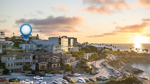 A coastal urban area with modern buildings, a parking lot, and a view of the ocean at sunset. - New - Modern Studio - Stunning Ocean View (San Diego)