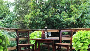 An outdoor patio with a wooden table, two chairs, and a woven rug. - Vineyard cottage Ranč pri Hanzeku (Videm)