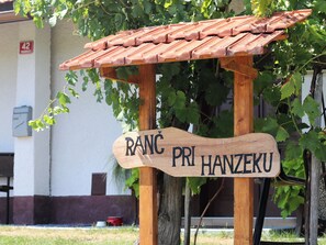 A wooden sign with the text "RANC PRI HANZEKU" under a tiled roof structure. - Vineyard cottage Ranč pri Hanzeku (Videm)