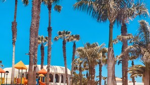 A playground with slides and a ping pong table. - Coral Bliss Apartment with Shared Pool, Private Terrace, and Wi-Fi (Corralejo)
