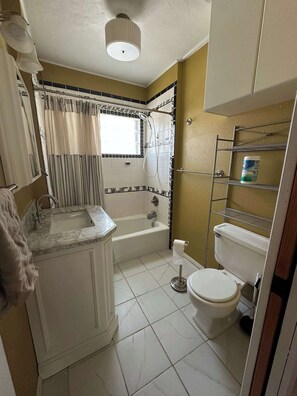 Une salle de bain avec une baignoire, des toilettes et un lavabo.