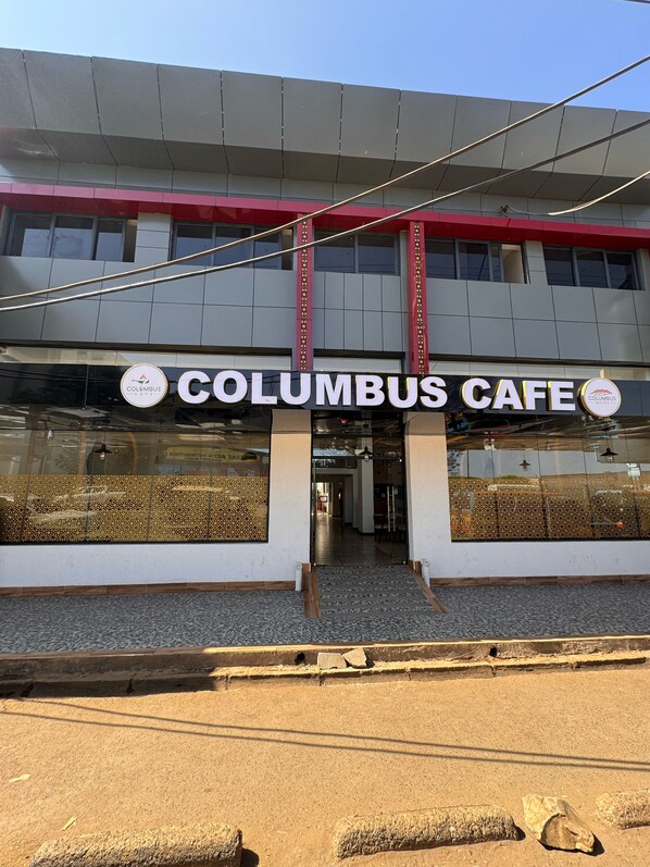 The Columbus Cafe building with a prominent sign, large windows, and a tiled entrance area. - Columbus Hotel Eldoret (Eldoret)