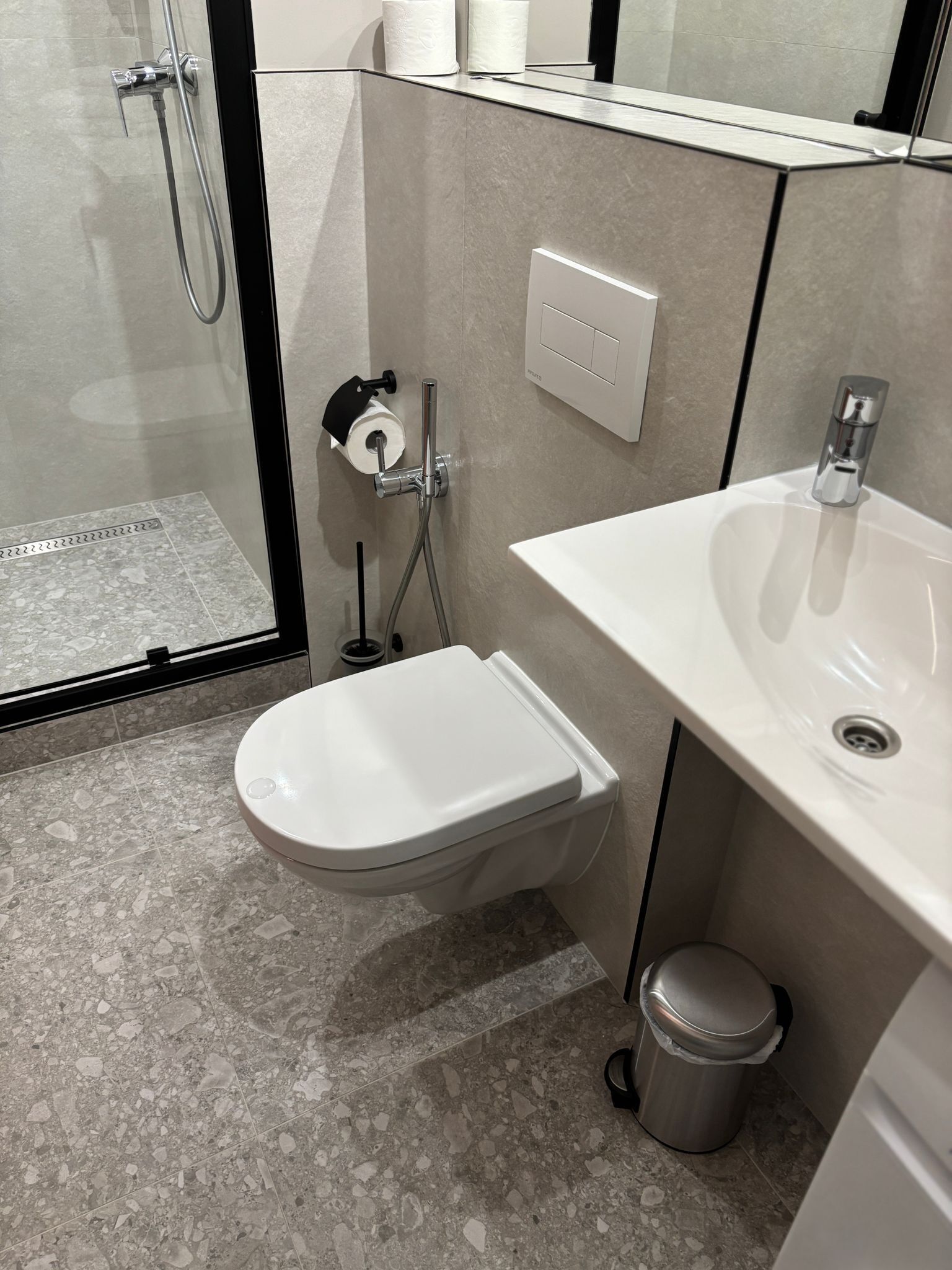 Uma casa de banho moderna com sanita, bidé e lavatório.