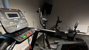 A home gym with a stationary bike, elliptical, and treadmill.