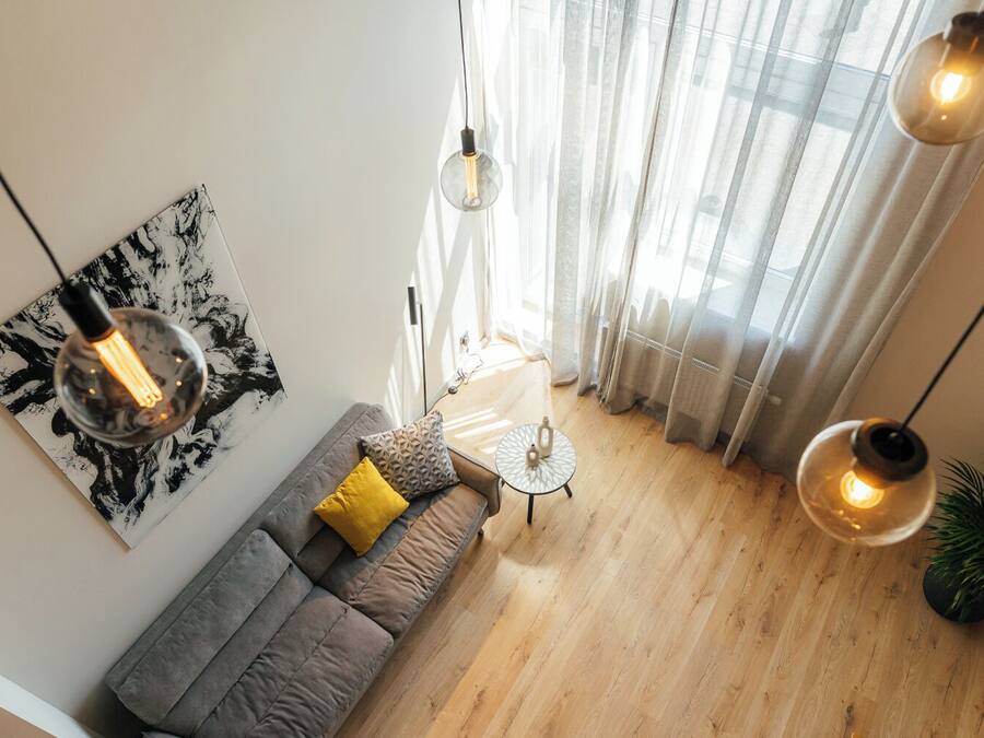 A modern living room with a gray sofa, a round coffee table, and a painting on the wall.