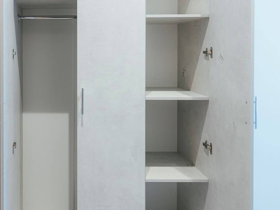 Armari amb porta corredissa i moltes prestatgeries i espai per penjar roba, amb un disseny minimalista i un terra de fusta clara.