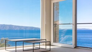 A balcony with a clear view of the sea and distant mountains.