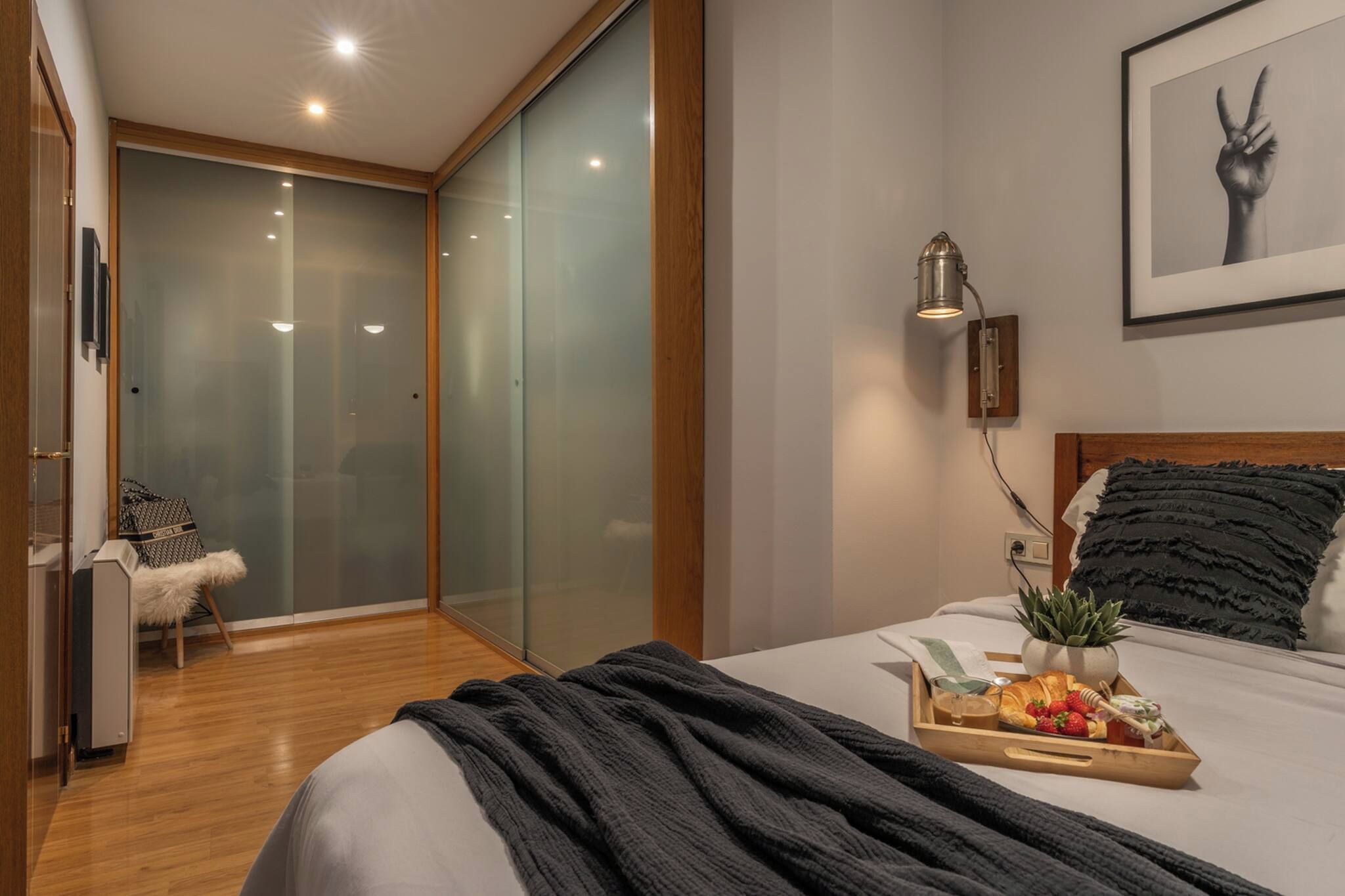 Une chambre moderne avec un lit, une table de chevet et un plateau contenant des éléments pour le petit-déjeuner.