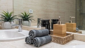 A bathroom with a sink, mirror, plants, and toiletries. - Cozy Home Casa Laura (Granada)