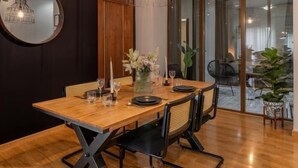 A dining area with a wooden table, black chairs, and a hanging light fixture. - Calma Center Granada (Granada)