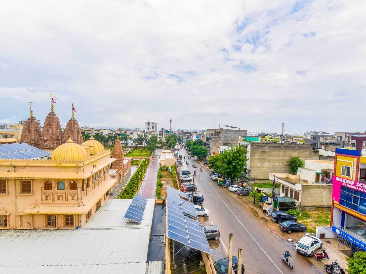 Une vue de rue avec un temple, des panneaux solaires et un bâtiment portant une enseigne.