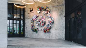 A modern interior with a concrete wall adorned with colorful, abstract art.