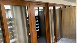 Un pasillo con puertas correderas de vidrio, piso de madera y alfombra estampada.