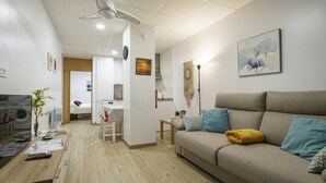 Una sala de estar moderna con un sofá, una mesa de centro, una mesa de comedor y una zona de cocina.