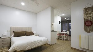 Une chambre à coucher avec un lit, une table de chevet, une lampe et un ventilateur de plafond.