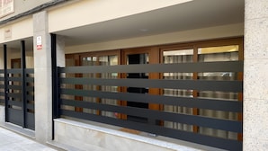 Fachada de edificio con entrada porticada, un letrero y una ventana que ofrece vista al interior.