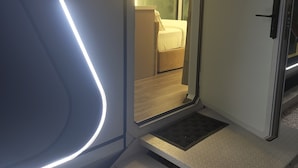 Una habitación de hotel con una cama, una puerta y una planta en maceta.