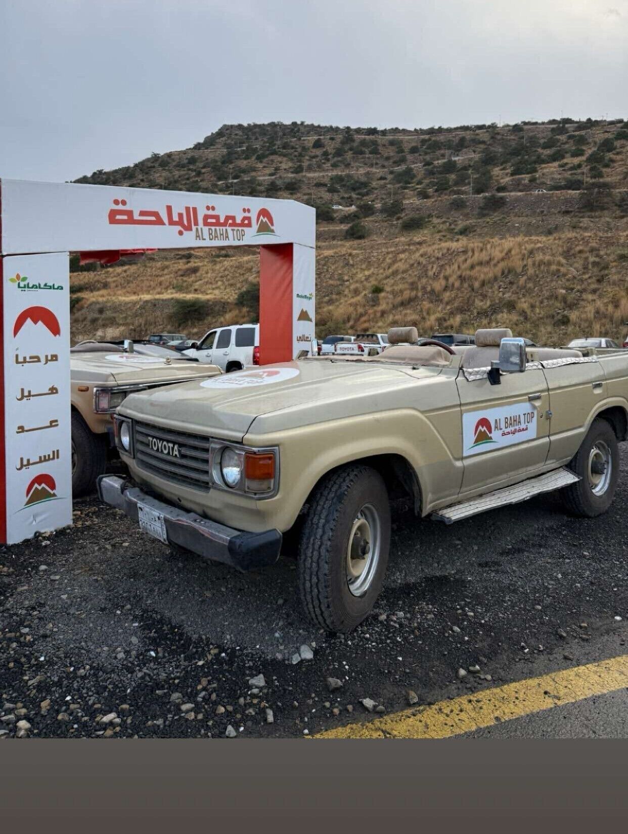 A Toyota vehicle parked at a checkpoint with a sign reading "Al Baha Top".