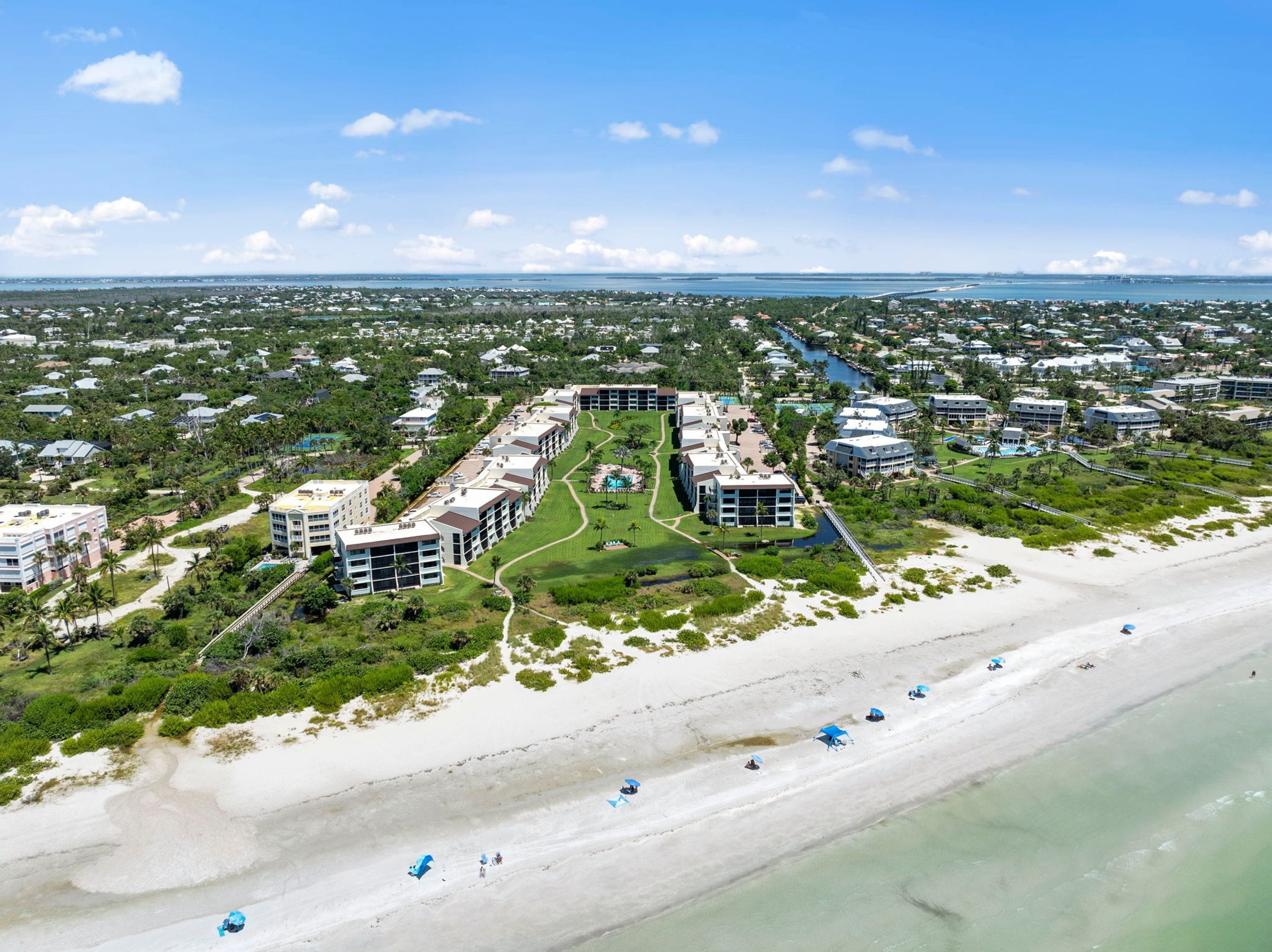 A coastal resort with multiple buildings, a beachfront, and a marina.