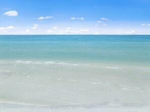 A beach with clear water and a sandy shore. - Loggerhead Cay 302 w Bikes Pool on Beach (Sanibel)