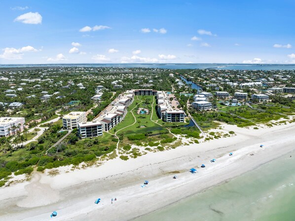 A coastal resort with multiple buildings, a beachfront, and a marina.