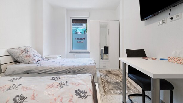 A bedroom with two beds, a desk, a chair, a TV, and a wardrobe. - Room '3' with Shared Terrace and Wi-Fi (Albstadt)