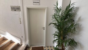A hallway with a white door, a sign indicating 'EINGANG' (entrance), a sign for 'DR. MED. H. MAYER NERVENARZ - PSYCHOTHERAPIE' (Neurology - Psychotherapy), and a potted plant. - Room '3' with Shared Terrace and Wi-Fi (Albstadt)