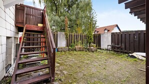 A backyard with a wooden staircase, a wooden fence, and a building in the background. - Room '3' with Shared Terrace and Wi-Fi (Albstadt)