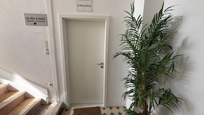 A hallway with a white door, a sign indicating 'EINGANG' (entrance), a sign for 'DR. MED. H. MAYER NERVENARZ - PSYCHOTHERAPIE' (Neurology - Psychotherapy), and a potted plant. - Room '4' with Shared Terrace and Wi-Fi (Albstadt)