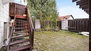 A backyard with a wooden staircase, a wooden fence, and a building in the background. - Room '4' with Shared Terrace and Wi-Fi (Albstadt)
