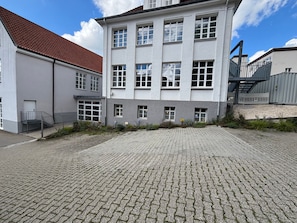 A building with a paved courtyard, multiple windows, and a staircase leading to an upper level. - Room '5' with Shared Terrace and Wi-Fi (Albstadt)
