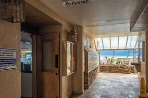 Ein Restaurant mit Blick auf den Strand, ein Schild für ausgewiesene Parkplätze und ein Warnschild bezüglich des Fußbodens.