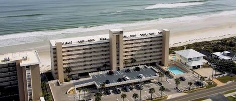 A 2-bed 2-bath oceanfront condominium with a 3-night minimum stay, featuring a parking lot and a pool.