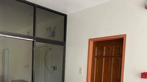 A room with a sliding glass door, a wooden door, and a water dispenser.