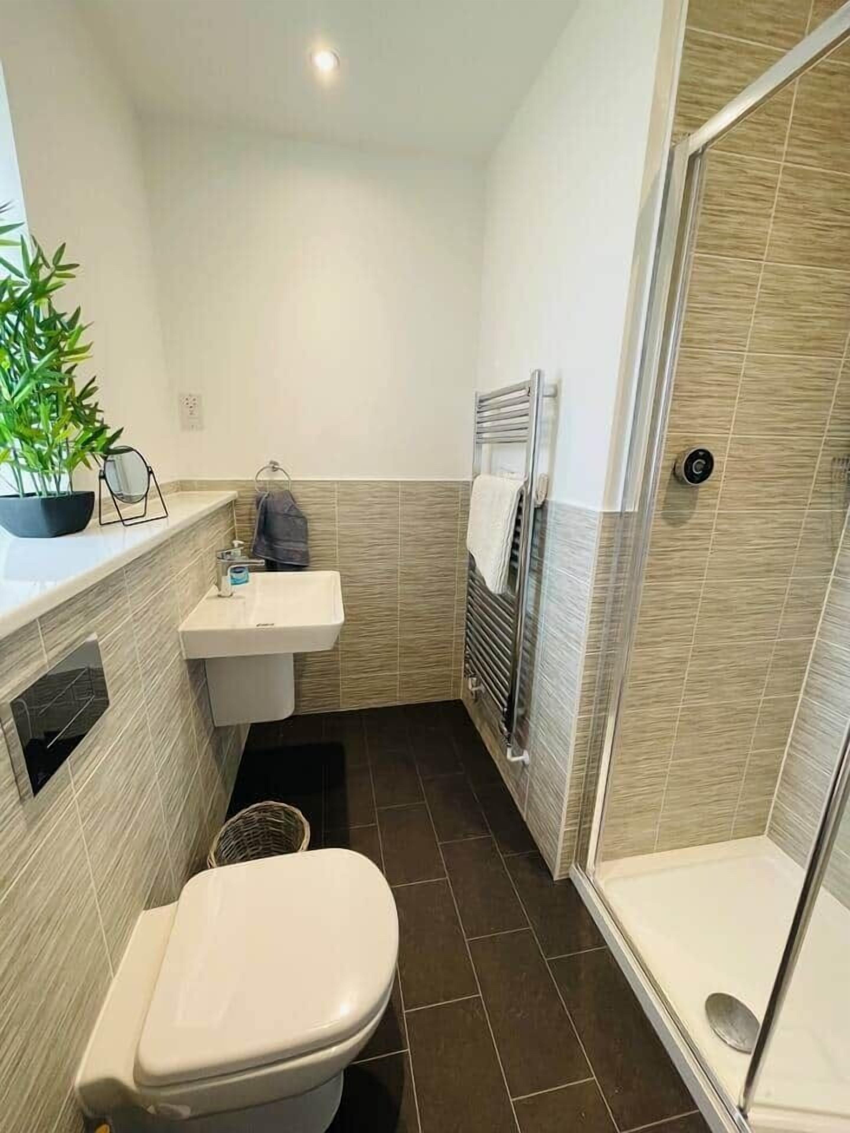 A compact bathroom with a toilet, sink, and shower.