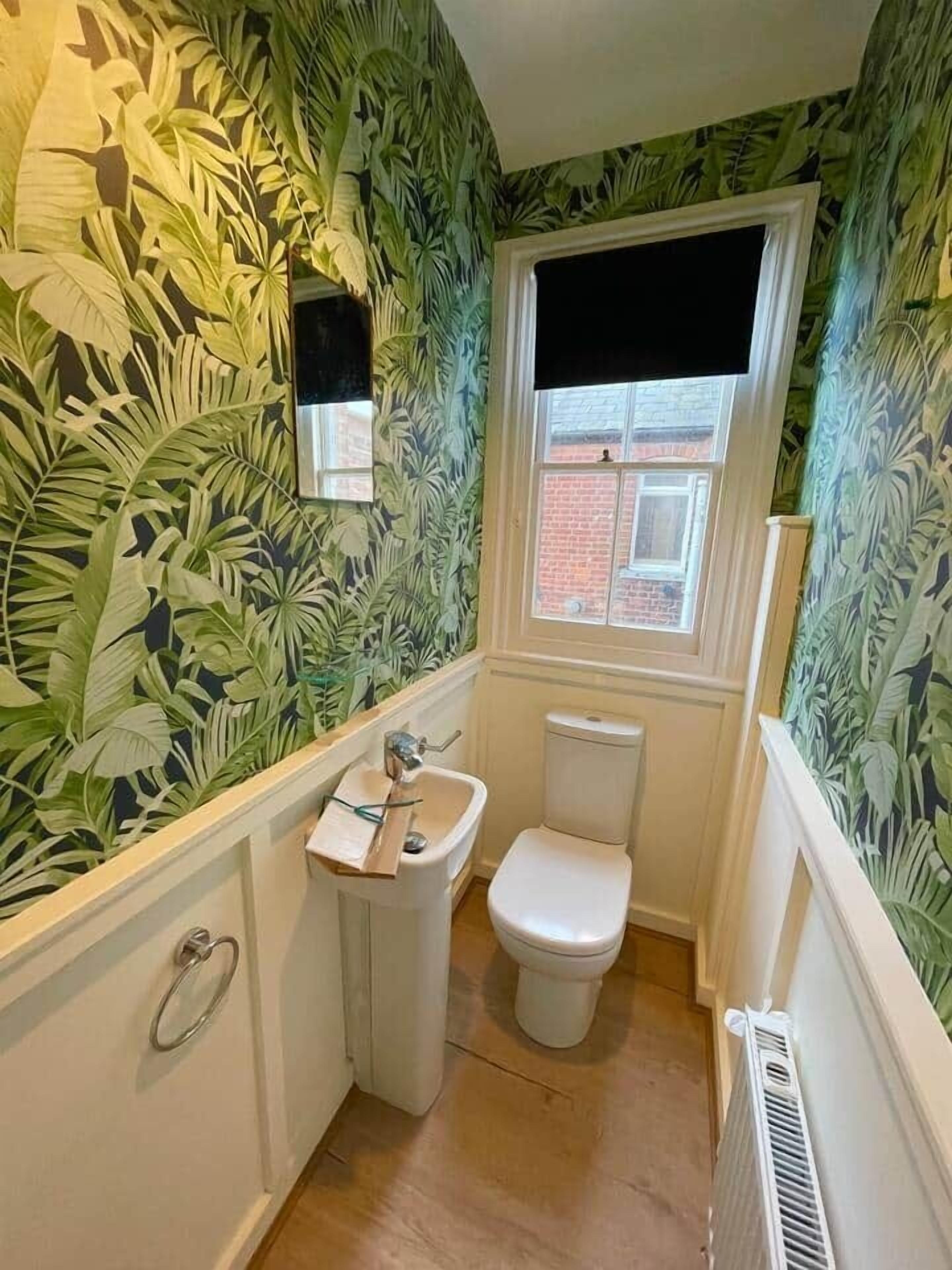 Un bagno piccolo con il water, un lavandino e una finestra.