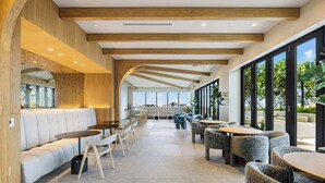 A modern interior with a long corridor, seating areas, and large windows offering views.