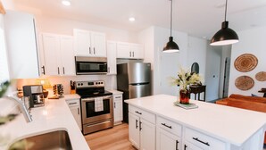 A modern kitchen with white cabinets, stainless steel appliances, and a central island. - Mid-Term Discounts - Near Downtown, UGA, Hospital (Athens)