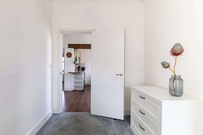 A hallway with a white door leading to a kitchen area.