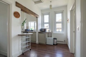 A kitchen with a white fridge, a microwave, a sink, and a window.