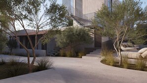 A modern building with a concrete facade, a staircase leading to an upper level, and a landscaped area with trees and shrubs. - Enliven Lifestyle Hotel Nicosia (Nicosia)