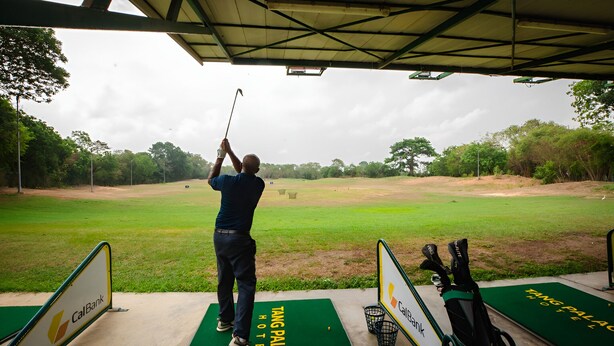 A golf course with a tee box, a putting green, and a golf bag. - Accra City Guest House (Accra North)
