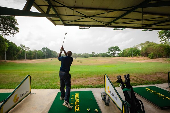 Een golfbaan met een tee en putting green, en een golftas.