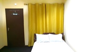 A room with a bed, a door, and curtains. - Accra City Guest House (Accra North)
