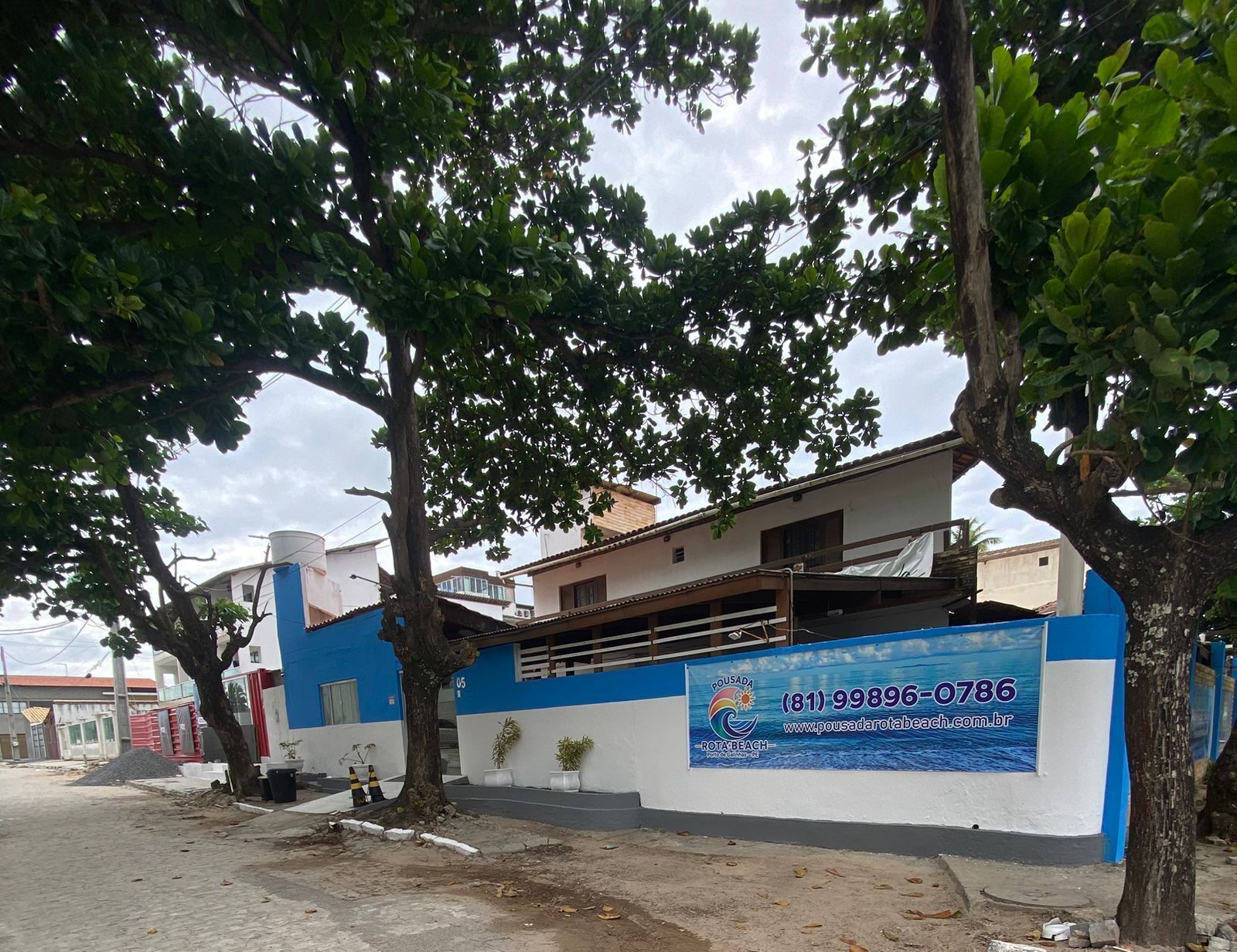 A building with a blue and white facade, a visible phone number, and a website address.