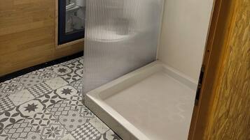 Een douche, handdoeken, zeep, shampoo