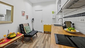 A compact living space with a kitchenette, a dining area with a table set for breakfast, and a seating area with a sofa.