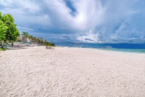 A wide sandy beach with a clear view of the ocean and a few buildings in the background. - Gulf Front Cottage w/ Heated Pool | Walk to Dining | Indian Rocks Beach (Indian Rocks Beach)
