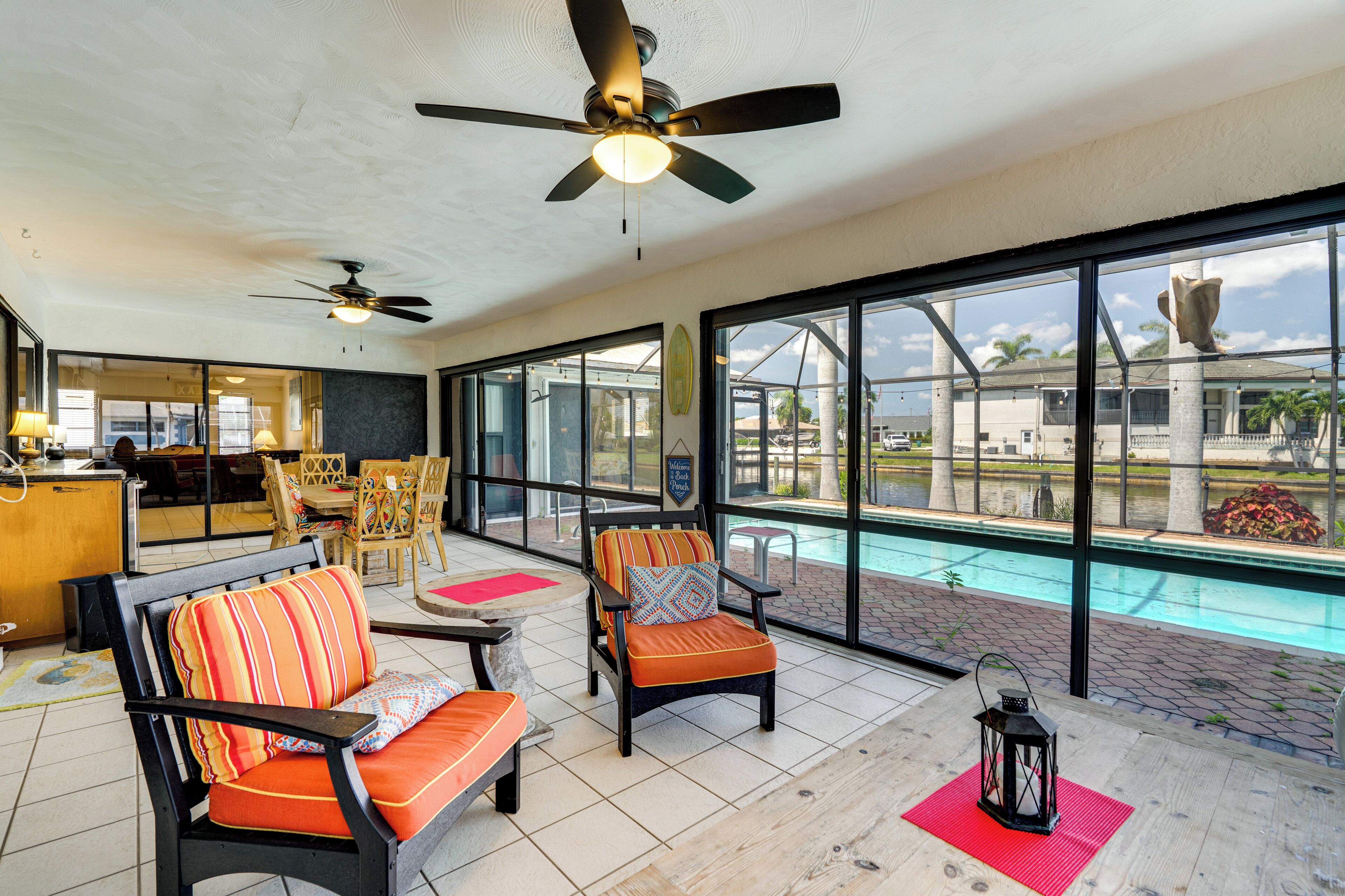 A spacious indoor area with a pool view, ceiling fans, and comfortable seating.